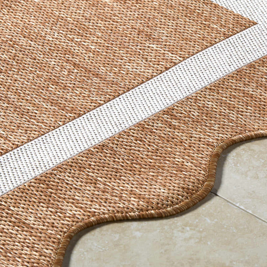 Close-up of Varro Rust Area Rug showing cream stripe, rust weave texture, and scalloped edge detail on tile flooring. Texture