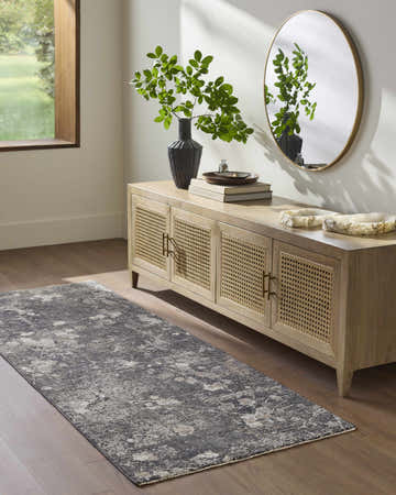 Entryway with wood floors and Aquila Black Area Rug. Console table with round mirror and green plant. Roomscene-Runner