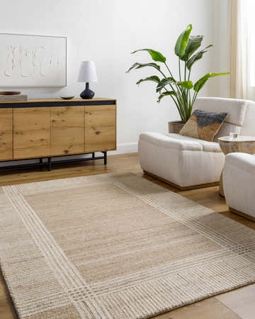 Living room scene with a beige Vlora Area Rug, cream armchairs, and a wooden sideboard. Modern, neutral tones. Roomscene-Rectangle