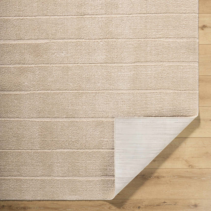 Close-up of the Cascade Brown Area Rug showing the light brown, textured design and non-slip backing. Fold