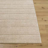 Close-up of the Cascade Brown Area Rug showing its light brown, textured, horizontal striped design on wood floor. Front