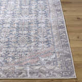 Close-up of the beige, blue, and brown Valar Washable Area Rug with a traditional pattern on a wood floor. Front