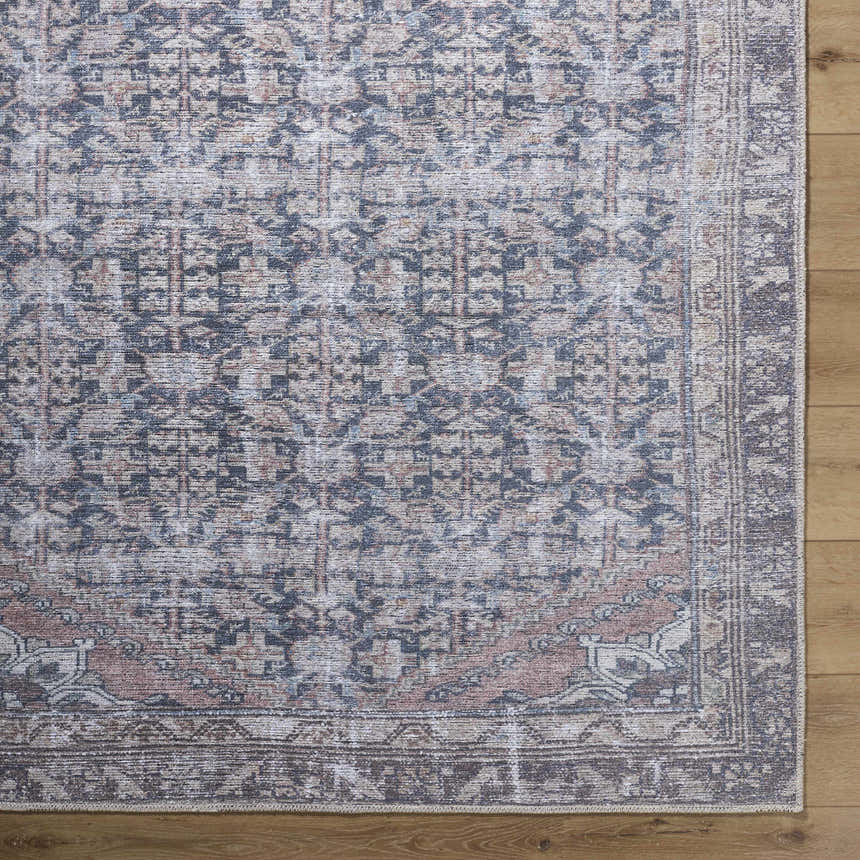 Close-up of the Valar Washable Area Rug showing its beige, black, and blue traditional pattern and soft texture. Corner