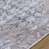 Close-up of the Valar Washable Area Rug showing beige, black, and blue traditional farmhouse pattern and soft polyester texture. Texture