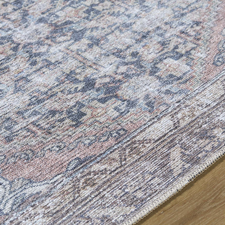 Close-up of the Valar Washable Area Rug showing beige, black, and blue traditional farmhouse pattern and soft polyester texture. Texture