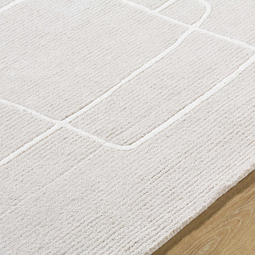 Close-up of the Vatsa Gray Abstract Area Rug, a hand-tufted wool rug with a geometric design in light silver and sterling gray. Texture