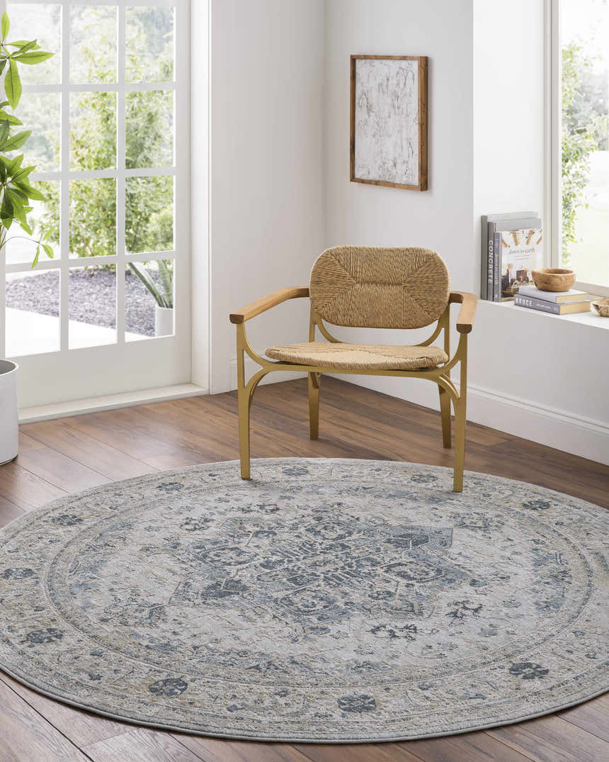 Light-filled room with round Whangamata Thick Luxe Boutique Rug, woven chair, and wood floors. The rug features a traditional, oriental pattern. Roomscene-Round