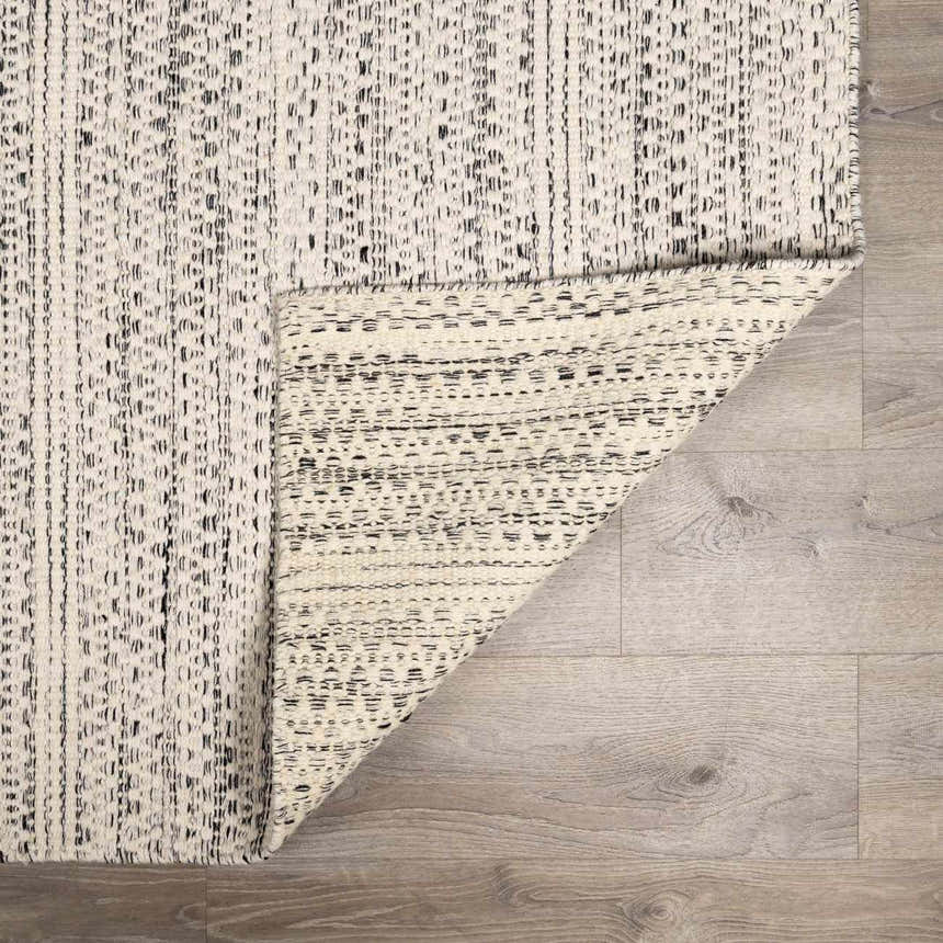 Close-up of the black and cream striped Williford Wool Area Rug showing texture and hand woven construction. Fold