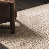 Close-up of the hand-woven Williford Wool Area Rug in cream and black, featuring a subtle striped pattern and textured weave. Styleshot