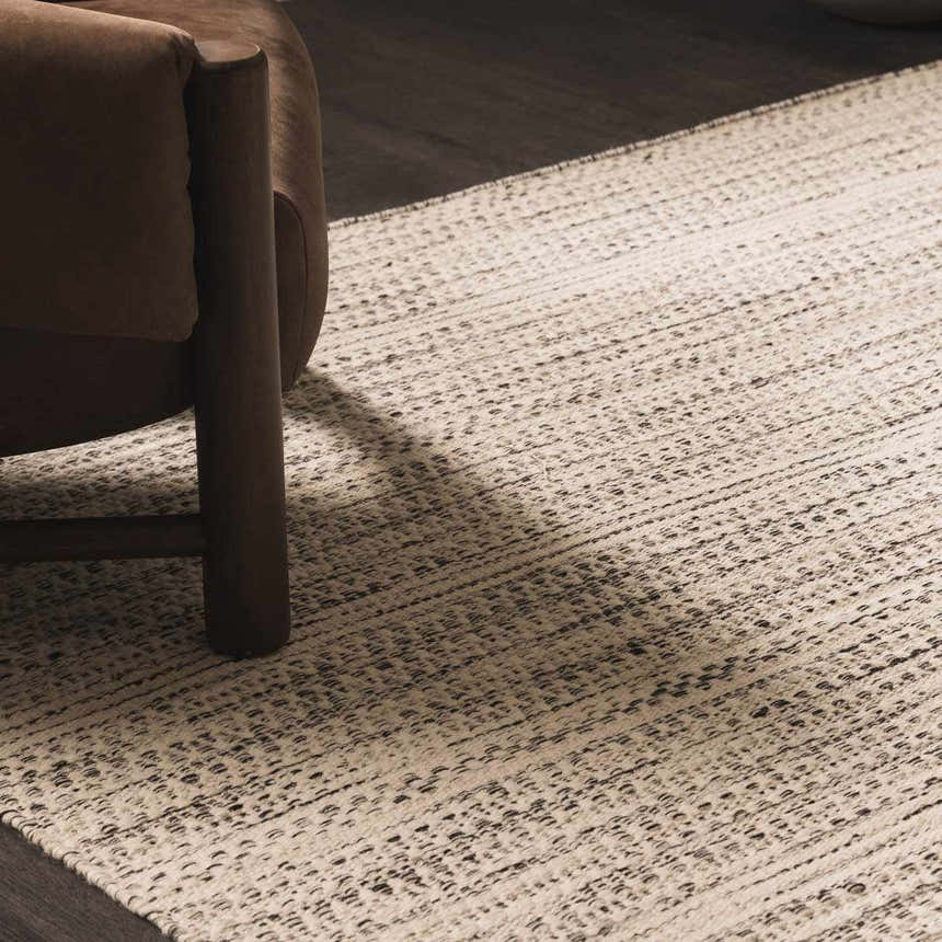 Close-up of the hand-woven Williford Wool Area Rug in cream and black, featuring a subtle striped pattern and textured weave. Styleshot
