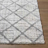 Close up of the Anuhea Off White Area Rug showing its shag texture and gray diamond pattern. Front