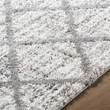 Close-up of the plush Anuhea Off White Area Rug, showing its soft texture and gray geometric pattern. Texture