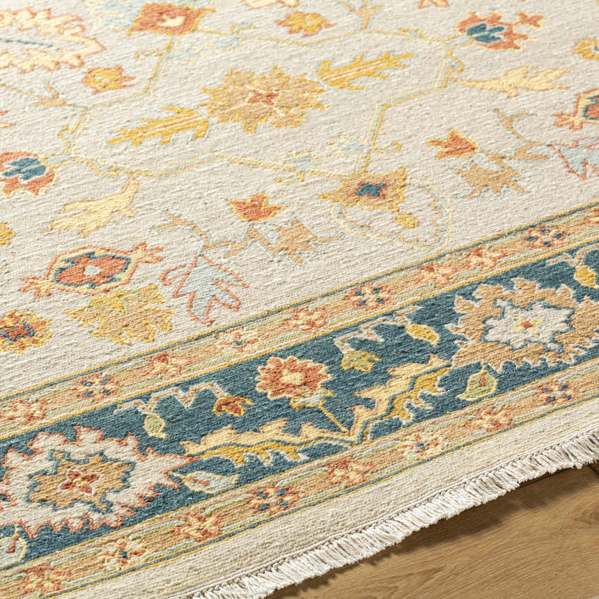 Close-up of the Yenimahalle Premium Rug. Hand-knotted wool rug in beige, teal, burnt orange, and mustard floral pattern. Texture