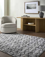 Contemporary living room with gray swivel chair and black geometric Yaqub Area Rug. Roomscene-Rectangle