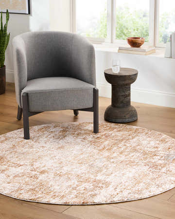 Living room scene with gray chair and round Yakov Area Rug in cream and tan. Roomscene-Round