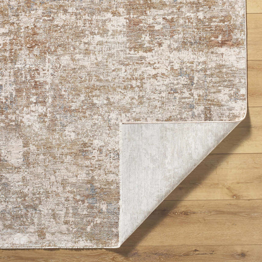 Close-up of the Yakov Area Rug, showing its cream, tan, and blue contemporary design and the rug's backing. Fold