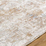 Close up of Yakov Area Rug showing cream, tan, and blue abstract pattern and soft texture. Texture