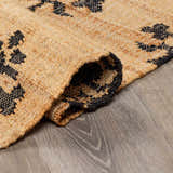 Close-up of the hand-woven Albina Florentine Jute&Wool Rug showing jute texture and black geometric pattern. Fold