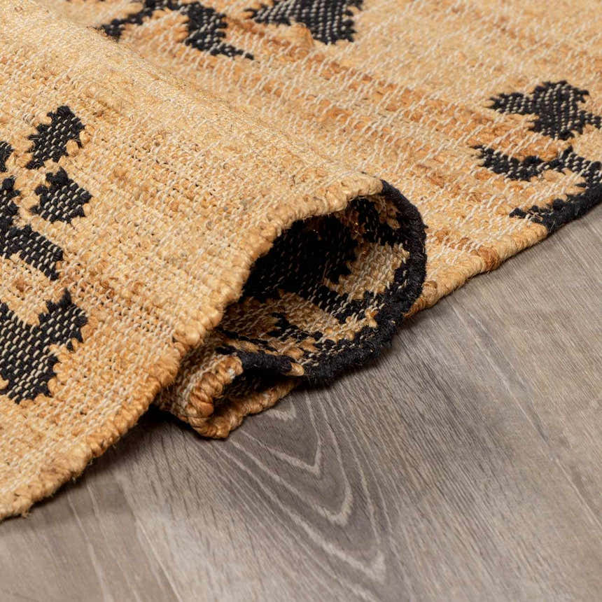 Close-up of the hand-woven Albina Florentine Jute&Wool Rug showing jute texture and black geometric pattern. Fold