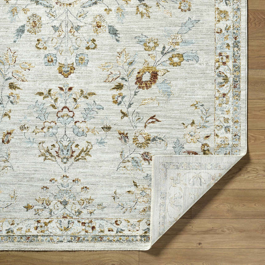 Close-up of the Yazid Area Rug, a cream rug with ivory, light gray, mustard, pale blue and sage floral pattern. Fold