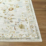 Close up of the Yazid Area Rug showing floral pattern in cream, ivory, mustard, sage and blue on wood floor. Front