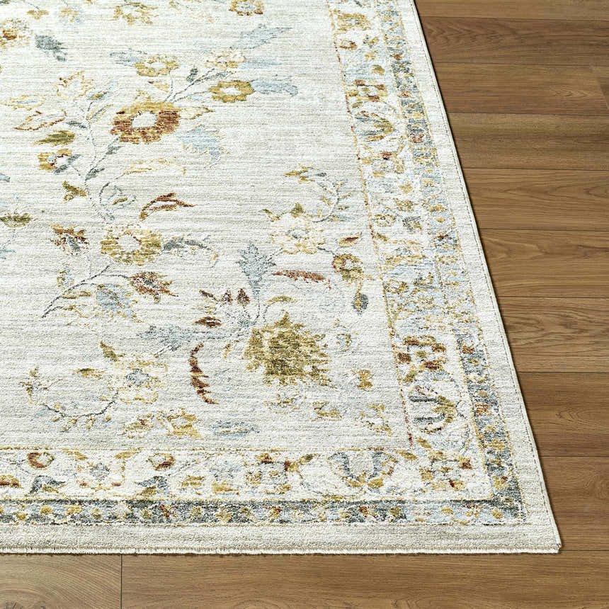 Close up of the Yazid Area Rug showing floral pattern in cream, ivory, mustard, sage and blue on wood floor. Front