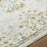 Close up of the Yazid Area Rug, showing cream, ivory, and pale blue floral pattern and soft texture. Texture