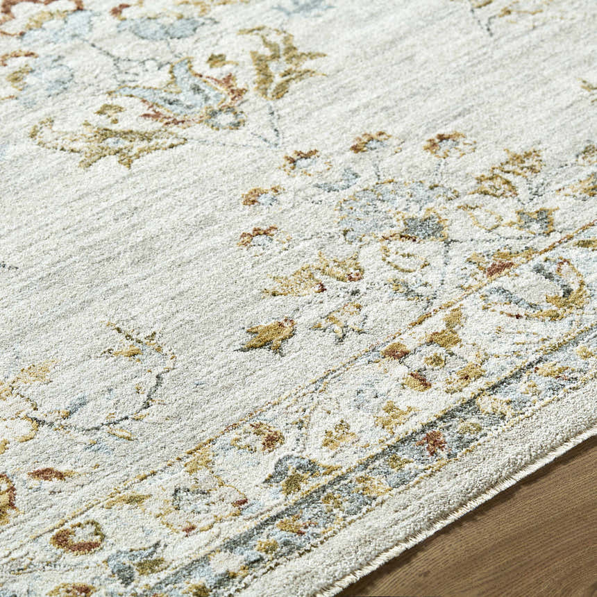 Close up of the Yazid Area Rug, showing cream, ivory, and pale blue floral pattern and soft texture. Texture