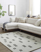 Living room scene with a modern ivory sofa and the Yitta Ivory Area Rug featuring a jet black dash pattern. Roomscene-Rectangle