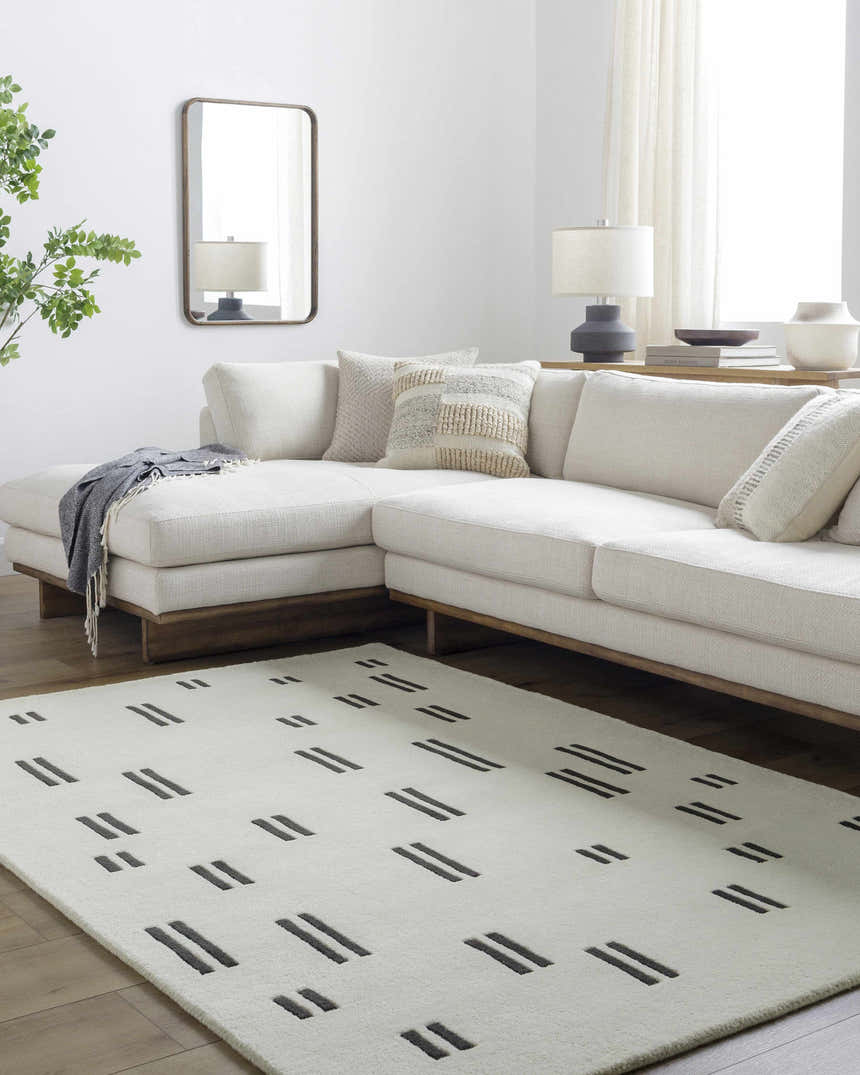 Living room scene with a modern ivory sofa and the Yitta Ivory Area Rug featuring a jet black dash pattern. Roomscene-Rectangle
