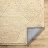 Close up of the hand tufted Addien Area Rug showing its wool texture and geometric line pattern. Fold