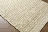 Close up of the hand woven Yaron Area Rug showing pearl and tan jute and wool texture. Corner
