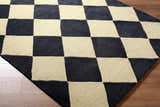 Close up of the Aradia Charcoal Area Rug featuring a bold black and beige checkerboard pattern. Corner
