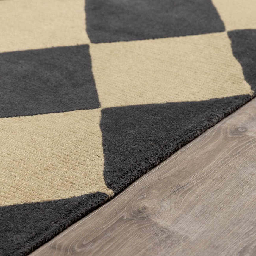 Close-up of the Aradia Charcoal Area Rug. A wool rug with a contemporary checkerboard pattern in charcoal and beige. Pile