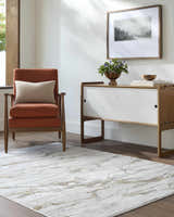 Living room scene with a beige Zelah Area Rug, orange chair, and modern white cabinet. Roomscene-Rectangle