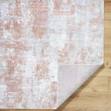 Close-up of the Anitra Brown Washable Area Rug. Features a brown, light gray, and white contemporary design. Fold