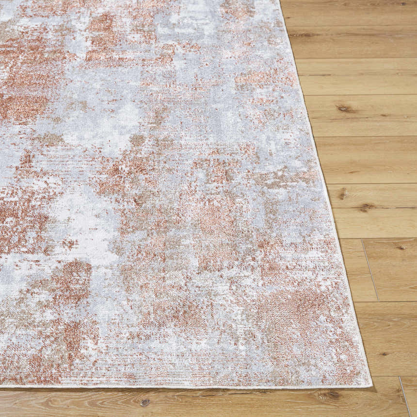 Close-up of the Anitra Brown Washable Area Rug. Features a contemporary brown, light gray, and white abstract design. Front