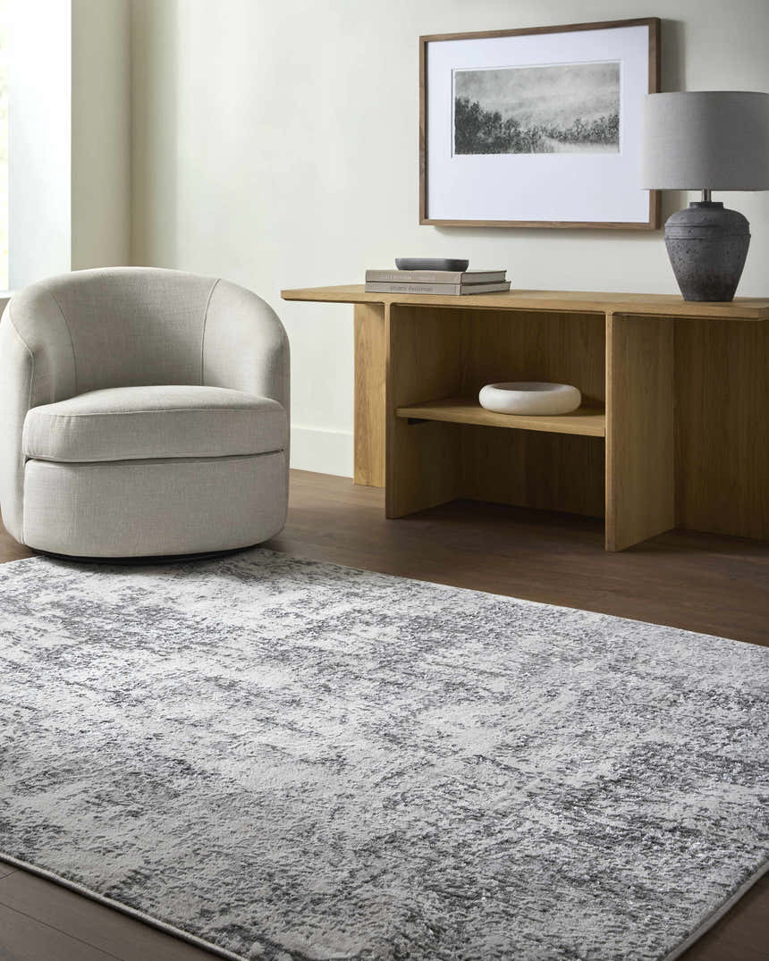 Living room scene with gray Alviva Area Rug, light gray chair, wood console table, and neutral decor. Roomscene-Rectangle