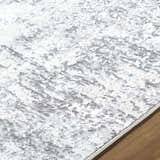 Close up of the Alviva Area Rug showing its charcoal, gray, and white contemporary pattern and soft texture. Texture