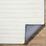 Close-up of the Zerah White Wool Area Rug showing the textured, horizontal line design and the rug's backing. Fold