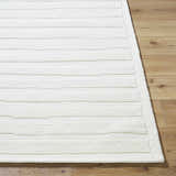 Close up of the Zerah White Wool Area Rug showing textured stripes on wood floor. Front