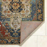 Close-up of the Zorea Traditional Area Rug showing the floral pattern, texture, and backing. Fold