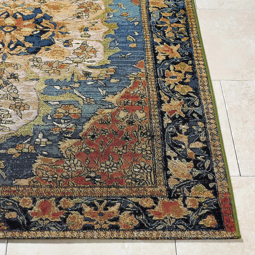 Close-up of Zorea Traditional Area Rug showing floral pattern in blue, red, gold, and black on tile floor. Front