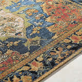 Close-up of the Zorea Traditional Area Rug, featuring a detailed floral pattern in blue, orange, gold, and black. Texture