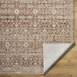 Close-up of the Ammiel Tan Area Rug featuring a traditional burnt orange, cream, and dark red floral pattern. Fold