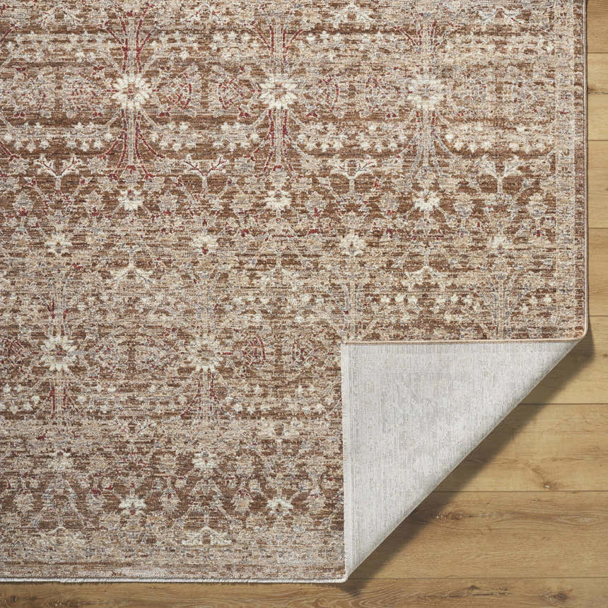 Close-up of the Ammiel Tan Area Rug featuring a traditional burnt orange, cream, and dark red floral pattern. Fold