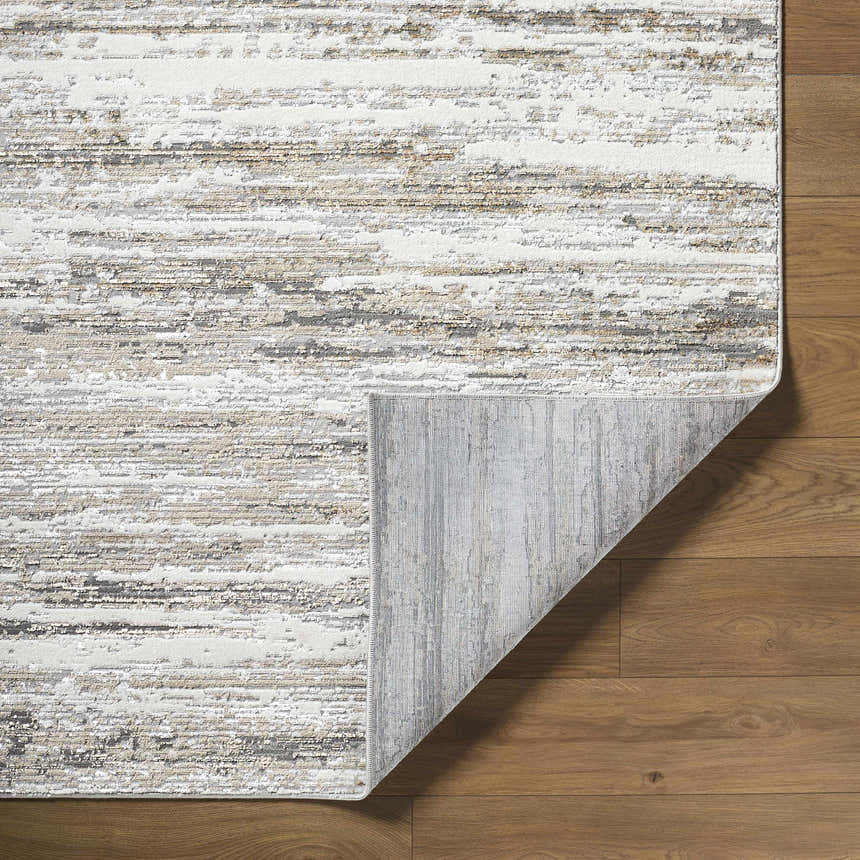 Close-up of the Aminia Area Rug showing a contemporary stripe design in charcoal, gray, brown, and white on a wood floor. Fold