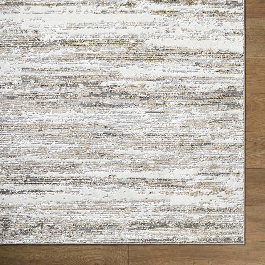 Close-up of the Aminia Area Rug. Contemporary design in charcoal, gray, light brown, and white on a wood floor. Corner