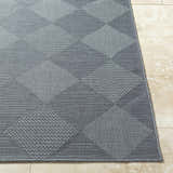Close-up of the gray Aulani Area Rug with a diamond pattern on beige tile flooring. Front