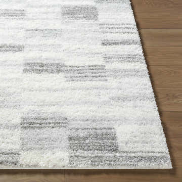 Close-up of the ivory and peach Alaura Area Rug, a contemporary shag with a geometric pattern and soft texture. Front